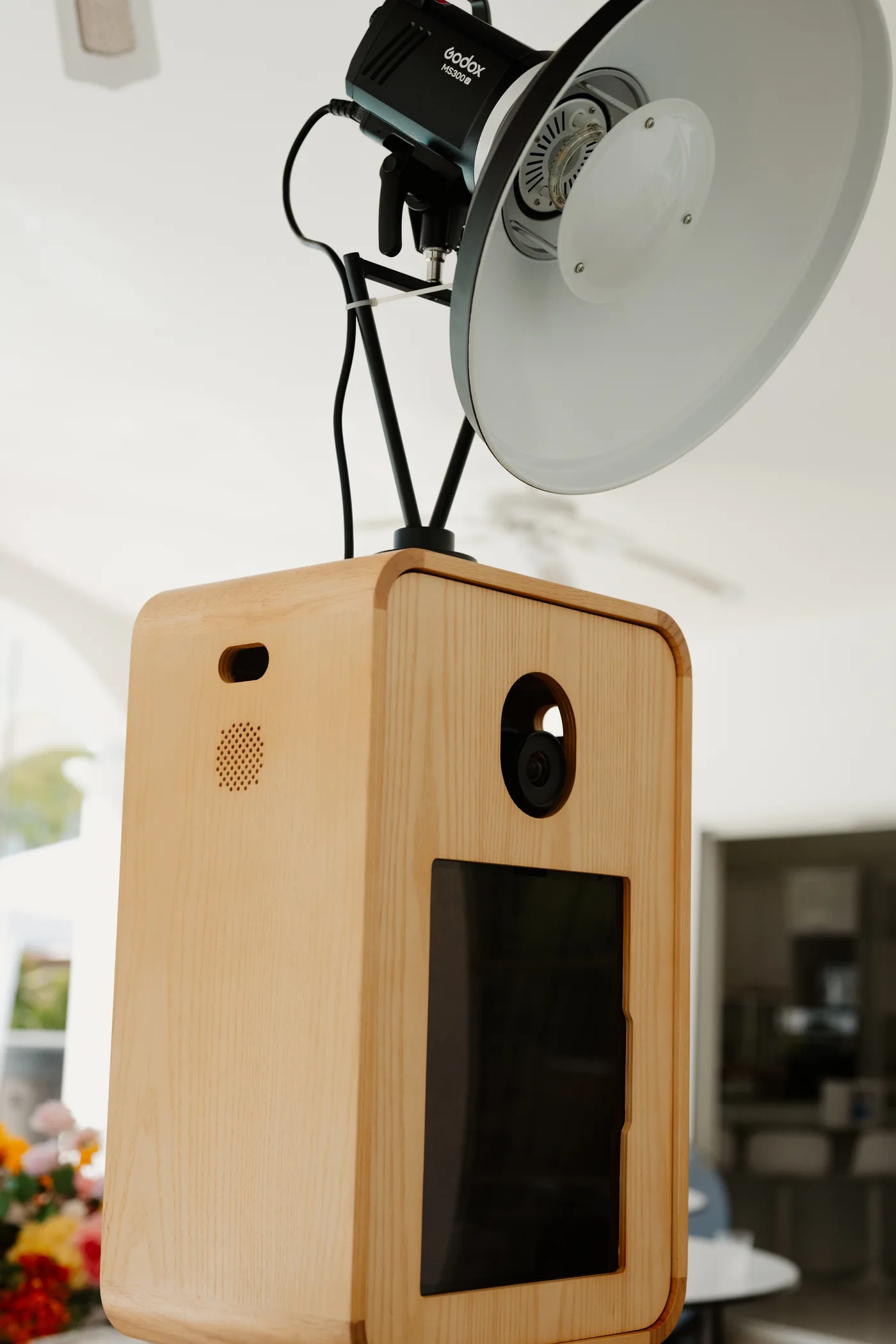 Détail du photobooth BELPOZ : boîtier en bois, objectif et flash professionnel Godox